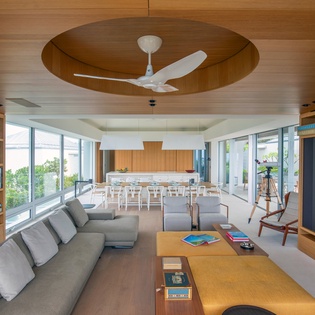 Your open-plan living space blends modern comfort with warm wood accents, perfect for relaxing with books or cooking together.