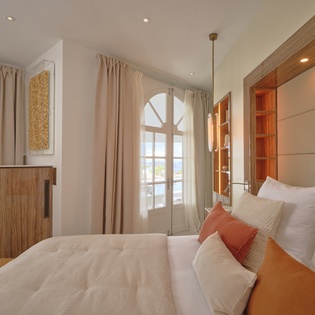 Sink into your tranquil bedroom sanctuary with crisp linens and warm wood accents, where French doors open to peaceful garden views.