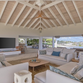 Relax in your airy living room with soaring vaulted ceilings, beachy coastal décor, and sweeping water views that invite the Caribbean indoors.