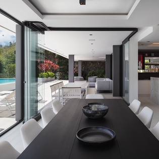 Your sophisticated dining space flows seamlessly to the pool terrace, where modern elegance meets tropical relaxation through floor-to-ceiling windows.