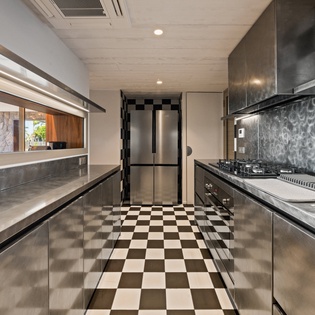 Cook your favorite meals in this sleek modern kitchen featuring premium stainless steel appliances and striking checkerboard floors.