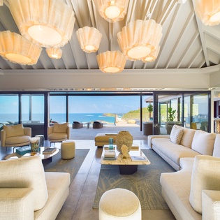 Sink into plush seating while you soak up breathtaking ocean views through floor-to-ceiling windows in this stunning living space.