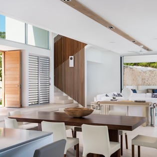 Step into your bright, open dining space where modern elegance meets tropical comfort through soaring ceilings and seamless indoor-outdoor flow.