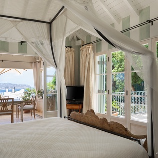 Wake up to gentle ocean breezes and stunning sea views from your elegant canopy bed. This airy retreat opens onto a private balcony where morning coffee meets paradise.