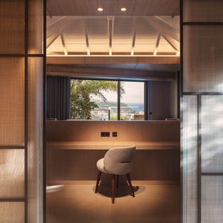 Your private work nook features warm wood tones and stunning sea views, creating the perfect blend of productivity and tranquility.