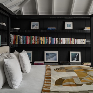 Curl up with your favorite book in this stylish living room, where floor-to-ceiling bookshelves and plush seating create the perfect reading retreat.