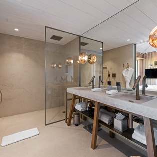 Your luxurious bathroom features a stunning glass-enclosed shower, elegant double vanity, and warm ambient lighting to create your perfect spa-like retreat.