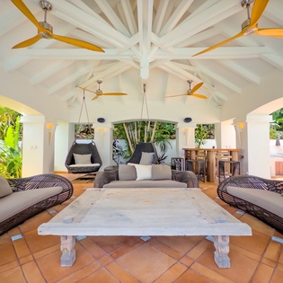 Unwind in this elegant open-air lounge where tropical breezes meet island style. Sink into plush seating and let lush greenery frame your perfect escape.