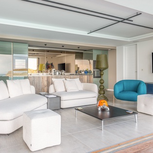 Sink into plush white sofas and enjoy your favorite shows on the large flat-screen TV in this bright, modern living space.