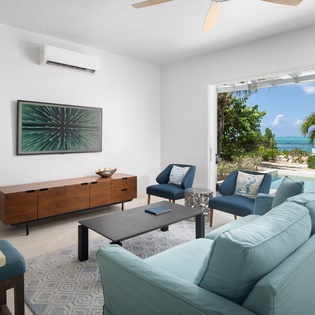 Sink into your spacious living room where ocean breezes flow through open doors to stunning sea views beyond.