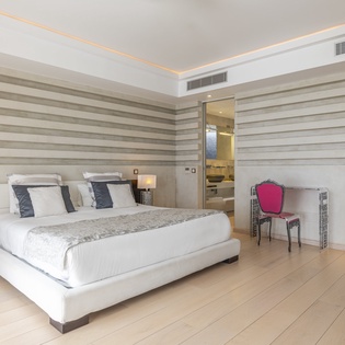 Sink into plush white linens and find your perfect retreat in this serene bedroom, where modern elegance meets total comfort. Soft lighting and subtle textures create a peaceful ambiance for your best night's sleep.