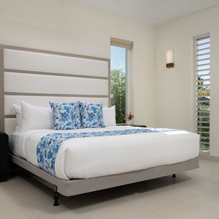 Wake up refreshed in your stylish bedroom with crisp linens and tropical touches.