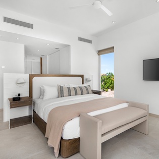 Unwind in your serene master suite with plush bedding, modern amenities, and peaceful garden views through oversized windows.