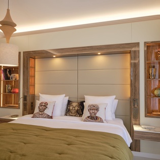 Sink into luxurious comfort in your beautifully appointed bedroom, where warm wood tones and artistic touches create the perfect sanctuary for restful nights.