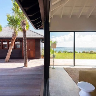 Step into a serene retreat where the ocean stretches before you, framed by floor-to-ceiling glass. Your private deck awaits beneath swaying palms, blending indoor comfort with coastal beauty in perfect harmony.