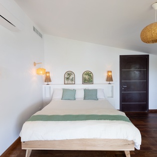 Unwind in your serene bedroom sanctuary, where tropical accents and warm lighting create the perfect space to rest and recharge.