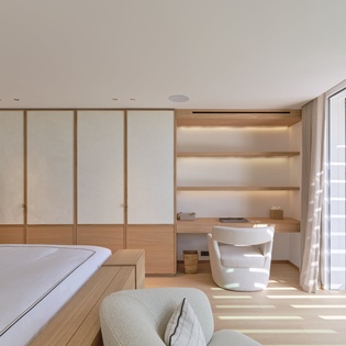 Unwind in your sleek bedroom's warm wood tones and minimalist elegance, where built-in storage meets tranquil style.