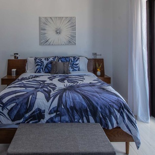 Wake up to turquoise waters and tropical breezes in your serene bedroom retreat. The stylish bedding invites restful sleep, while floor-to-ceiling windows frame stunning pool and beach views.