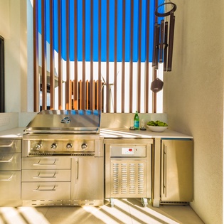 Your private outdoor kitchen awaits, with gleaming stainless-steel appliances and a spacious grill ready for al fresco dining under sunny skies.