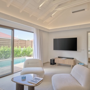 Relax in your bright living space with floor-to-ceiling windows overlooking your private pool and lush garden.