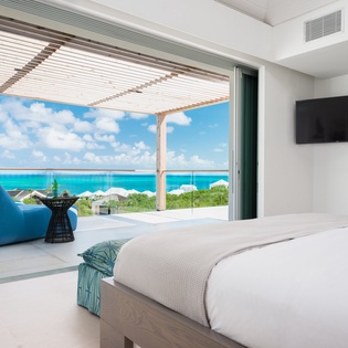 Wake up to stunning turquoise waters from your luxurious bedroom, where floor-to-ceiling windows frame breathtaking ocean views.