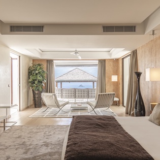 Unwind in your elegant suite, where natural light floods the space and a glimpse of the ocean awaits just beyond your private balcony.