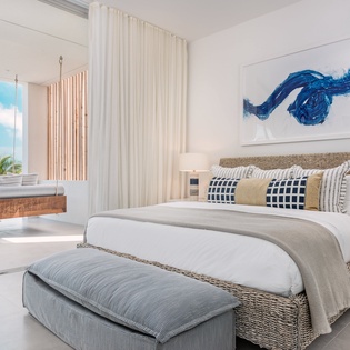 Wake up in your serene beachfront bedroom where ocean breezes flow through open doors and tropical views greet you each morning.