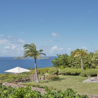 Tropical paradise awaits with manicured gardens, swaying palms, and pristine ocean views stretching to distant islands.