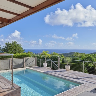 Dive into your private pool overlooking endless ocean and lush tropical hills—your perfect paradise retreat.