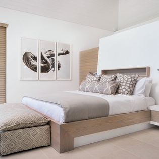 Sink into your peaceful retreat with crisp linens, modern design, and natural light filtering through bamboo blinds.