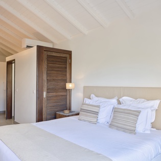 Drift into peaceful sleep in your serene bedroom, where exposed wooden beams and crisp white linens create the perfect retreat.