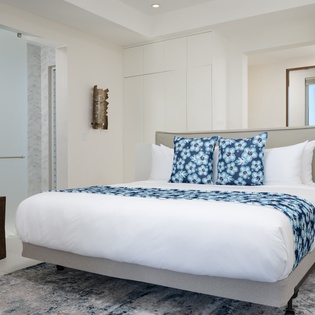 Slip into crisp white linens adorned with vibrant blue patterns in your serene bedroom sanctuary.