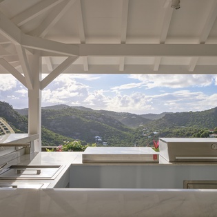 Your gourmet kitchen opens to breathtaking tropical mountain views, creating the perfect backdrop for cooking while enjoying paradise.