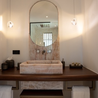 Step into your spa-like sanctuary with elegant marble finishes, warm pendant lighting, and luxurious amenities awaiting your arrival.