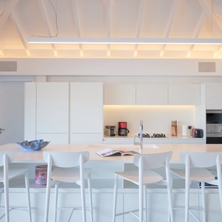 Cook together at your sleek marble island, where modern appliances and warm lighting create the perfect gathering space.