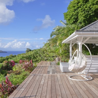 Sway in your hanging chair while gazing at endless ocean views from this stunning tropical deck.