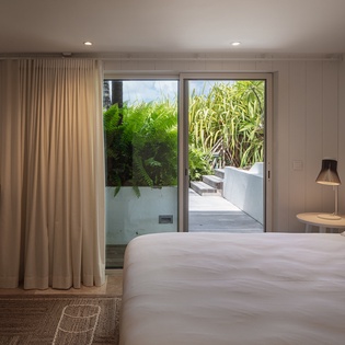Step into your serene bedroom retreat with crisp linens and peaceful garden views—your private sanctuary awaits just beyond those sliding doors.