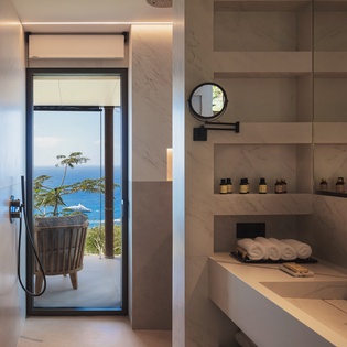 Step into your spa-like marble bathroom where floor-to-ceiling windows frame stunning ocean views, creating a tranquil sanctuary for your daily rituals.