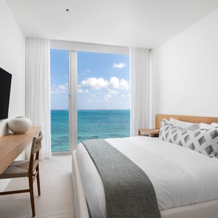 Wake up to endless ocean views from your comfortable bed, where floor-to-ceiling windows frame the turquoise sea perfectly.