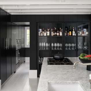Your sleek kitchen features modern black cabinetry, marble countertops, and a well-stocked bar area perfect for entertaining.