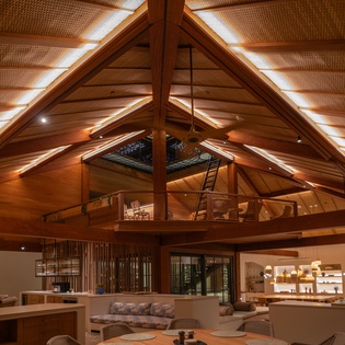 Soaring wood beams frame your open-concept haven, where natural light filters through skylights above your cozy living space and gourmet kitchen.