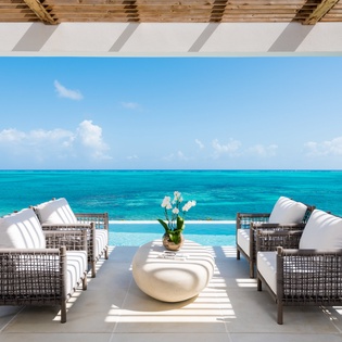 Unwind in your private oceanfront lounge where turquoise waters meet endless sky, creating the perfect backdrop for morning coffee or sunset cocktails.