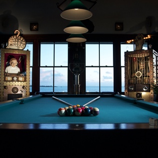 Challenge friends to a game in your stylish billiards room, where vintage arcade machines and ocean views create the perfect entertainment escape.