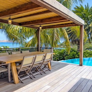 Picture yourself dining under this covered terrace, where swaying palms frame stunning ocean views and your private infinity pool awaits steps away—a perfect tropical retreat.