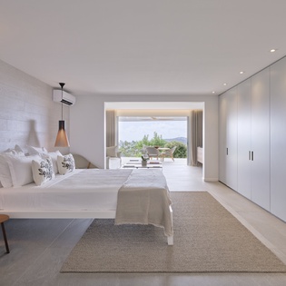 Wake up in your serene master bedroom, where modern pendant lights cast a warm glow over crisp linens and mountain views frame your mornings.