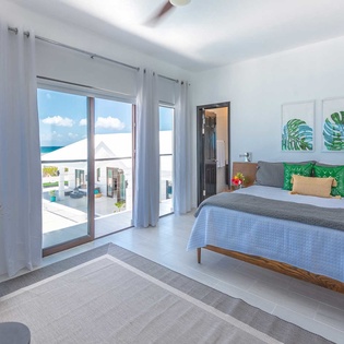 Wake up to stunning turquoise waters framed by floor-to-ceiling windows. Your oceanfront retreat features tropical-inspired décor and a private terrace just steps from your bed.