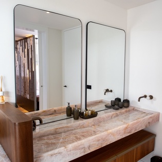 Indulge in your marble double vanity with premium amenities and sleek mirrors for morning routines.