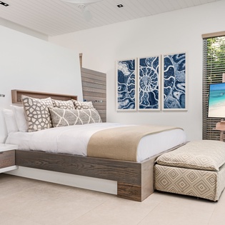 Your sophisticated bedroom offers coastal serenity with ocean-inspired artwork, luxury linens, and a smart TV for your comfort.