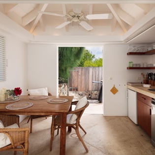 Relax in your open dining and kitchen space with cathedral ceilings and a ceiling fan, where meals are just steps from the lush garden patio.