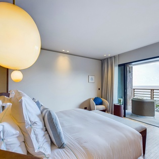 Wake up to serene mornings in your elegant bedroom, where warm pendant lighting and crisp linens create the perfect retreat after exploring.